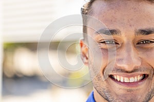 Close-up portrait of handsome caucasian young man with brown eyes smiling and looking at camera