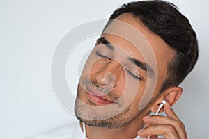 Close-up portrait of handsome caucasian young man enjoying his favorite music. Happy stylish smiling man in headphones