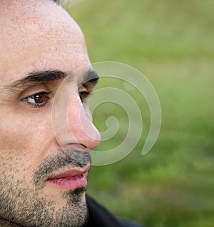 Close up portrait of a handsome man looking away on  blurry green background photo