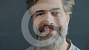 Close-up portrait of handsome mature man smiling and laughing looking at camera