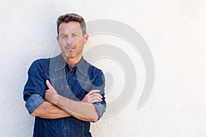 Close up handsome older man standing and thinking with arms crossed