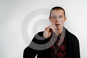 Close up portrait of handsome serious man of modern appearance with short haircut in black sweater isolated on gray