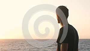 Close up portrait of handsome young man looking thoughtful pensive on seaside background.