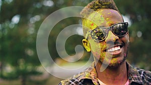 Close-up portrait of happy African Americn guy hipster looking at camera and smiling at Holi festival with face and hair