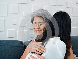 Close-up portrait of happy Asian senior, mother or grandparent white hair embracing her beautiful daughter.