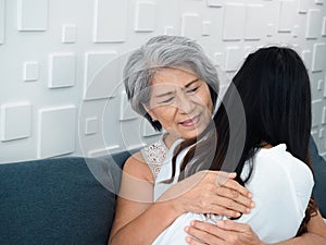 Close-up portrait of happy Asian senior, mother or grandparent white hair embracing her beautiful daughter or grandchild.