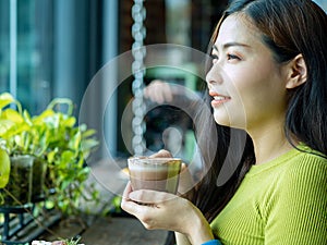 Close-Up Portrait of a Happy Asian woman with a Latte at the Cafe