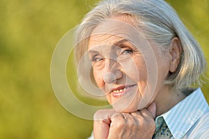Close up portrait of happy beautiful elderly woman posing outdoors