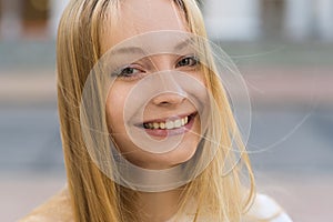 Close-up portrait of a happy blonde girl in casual clothes. Lifestyle concept