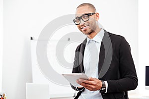 Close-up portrait of a happy businessman holding pc tablet