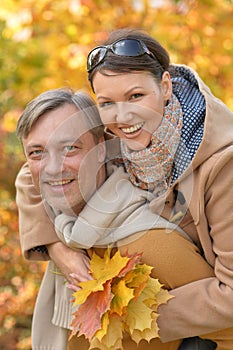 Close up portrait of happy couple posing in autumnal park