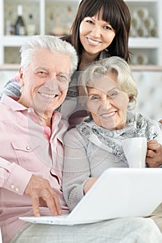 Close-up portrait of happy family with laptop at home