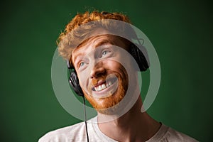 Close-up portrait of happy hipster readhead man listening music