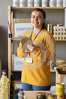 Close up portrait of happy joyful young woman in charity center volunteer typing on tablet browsing online and smiling