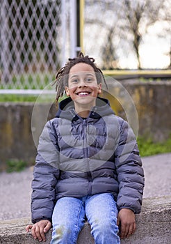 Close up portrait of a happy little boy smiling, looking directly at the camera, laughing