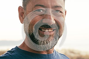 Close up portrait of happy man cheerful looking on camera. One adult mature male caucasian smile with confident and serene