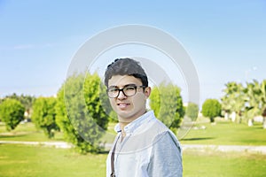 Close up portrait of a happy man standing outdoors with bag.