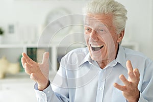 Close up portrait of happy senior man at home