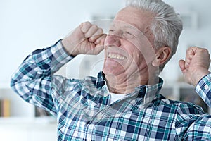 Close up portrait of happy senior man posing at home