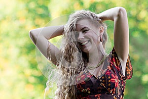 Close-up portrait of happy, smiling, laughing blonde girl in summer