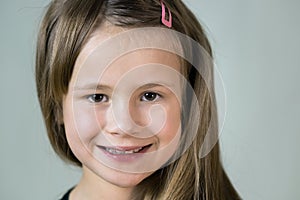 Close-up portrait of happy smiling little girl with long hair