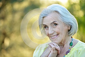 Close up portrait of happy smiling senior woman in park