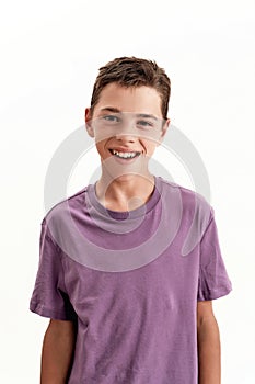 Close up portrait of happy teenaged disabled boy with cerebral palsy smiling at camera, posing isolated over white
