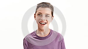 Close up portrait of happy teenaged disabled boy with cerebral palsy smiling at camera, posing isolated over white