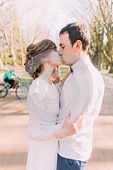 Close-up portrait of happy wedding couple, bride and groom kissing in th spring park
