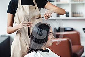 Close up portrait of happy woman getting cut of split ends at hairdresser`s