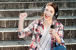 Close-up portrait of happy woman listening to music on headphon