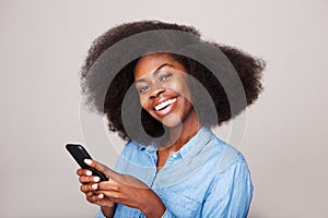Close up portrait of happy young african american woman smiling with mobile phone photo