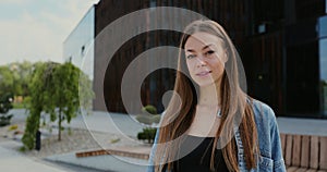 Close-up portrait of a happy young beautiful woman with long hair. Young woman looking into camera and smiling.