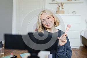 Close up portrait of happy young beauty blogger, records lifestyle vlog in her room, using camera with stabiliser, shows