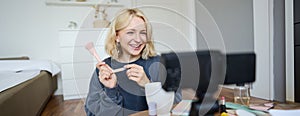 Close up portrait of happy young beauty blogger, records lifestyle vlog in her room, using camera with stabiliser, shows