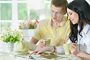 Close up portrait of happy young couple reading interesting book