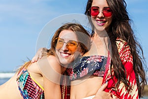 close-up portrait of happy young women in bikini embracing