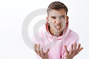 Close-up portrait of hateful, annoyed and bothered blond man arguing, swearing and cursing person, feel upset over