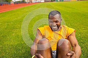 Close up portrait of healthy young afro american black man doing crunches outdoors at the stadium, keep his body fit