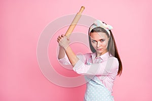 Close-up portrait of her she nice attractive dangerous angry serious housewife holding in hands wooden rolling pin
