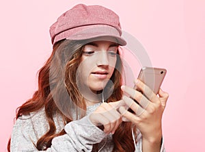 Close-up portrait of her she nice-looking attractive girl wearing pink hat using cell web app isolated