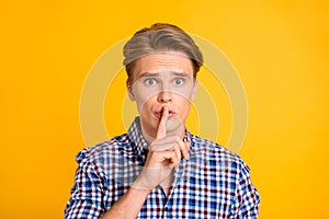 Close-up portrait of his he nice-looking attractive worried nervous guy wearing checked shirt showing shh sign keep dont