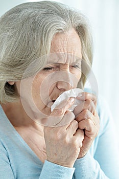 Close-up portrait of ill senior woman coughing