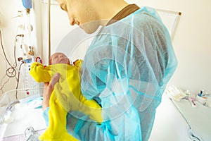 Close-up portrait of infant hold by father in ICU