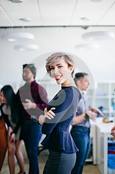 Close up portrait of joyful businesswoman with crossed arms showing tongue