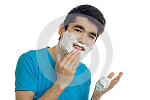 A close-up portrait of the joyful charming guy who strikes hands foam beard