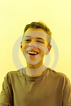 Close up portrait of joyful teenaged disabled boy with cerebral palsy smiling at camera while posing isolated over
