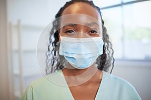 Close up portrait of junior doctor or nurse wearing surgical mask in scrubs photo