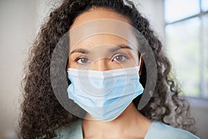 Close up portrait of junior doctor or nurse wearing surgical mask in scrubs photo