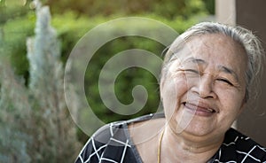 Close up portrait of kind Asian senior woman smiling at camera at home